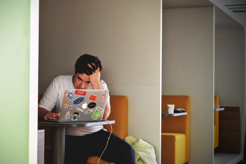 Frustrated man working on computer doing freelance work